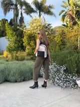 Mochila urbana color gris con detalles en cuero sintético negro. Cuenta con un compartimento principal amplio y un bolsillo frontal con cierre.