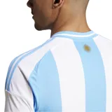 Camiseta de fútbol Adidas de la Selección Argentina, modelo titular 2024. Diseño a rayas verticales celestes y blancas con detalles dorados en logos y escudo.