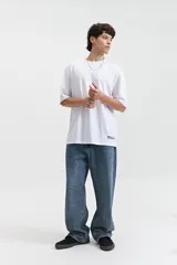 Remera blanca de manga corta con corte oversize y cuello redondo.