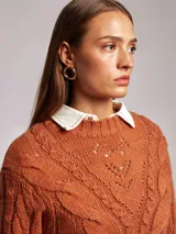 Sweater trenzado en color tostado, con diseño oversize y manga larga.