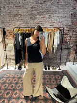 Musculosa negra con bordado floral, escote en V y breteles finos.