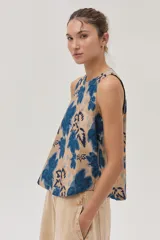 Blusa sin mangas estampada en tonos azul y camel, confeccionada en lino viscosa, fresca y ligera.