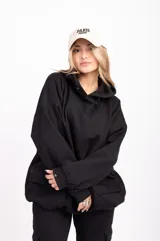 Canguro negro oversize con capucha y bolsillos frontales con solapa.