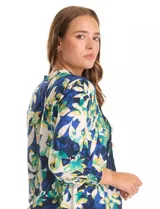 Blusa estampada de la marca Ruby Rd., con cuello a la base, escote en V y botones. Presenta manga larga con puño elastizado y delantera plisada. El estampado es de hojas en tonos azules, verdes, amarillos y blancos.