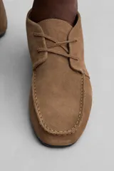 Botín marrón de gamuza con cordones y suela fina.