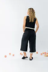 Top de lino color crudo, con escote cuadrado y detalle de guarda ondulada negra en el ruedo.