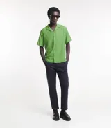 Camisa de hombre color verde claro, corte slim, de manga corta y cuello inglés. Confeccionada en viscosa texturizada.