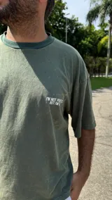 Remera verde militar de corte boxy con cuello redondo y estampado frontal con la frase "I'm not perfect but I'm limited edition".