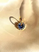 Arito dorado con forma circular, centro negro y strass blancos alrededor. Se vende por unidad.