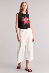 Musculosa negra de calce regular, cuello redondo y sin mangas. Estampa de flor roja en el frente.