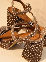 Sandalias de cuero color chocolate con estampado de lunares blancos, plataforma delantera y tacón cuadrado.