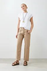 Remera blanca de algodón con cuello redondo y mangas cortas con detalle de broderie y vainillas.