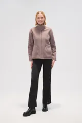 Campera color lila de micropolar con cuello alto, cierre frontal y bolsillos laterales.