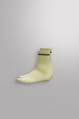 Calcetines deportivos color verde oliva con estructura compacta y elástica, terminación en ribete y una franja gris en la parte superior.