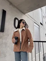 Campera marrón de pana con cierre frontal, cuello de piel sintética y bolsillos laterales.