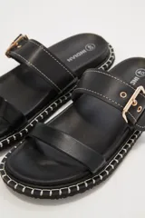 Sandalias negras de cuero sintético con doble tira y hebilla dorada ajustable.