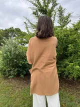 Kimono color camel confeccionado en muselina 100% algodón, con mangas 3/4 y bolsillos frontales.