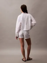 Short blanco de tiro alto con diseño de 5 bolsillos, cierre con botón y cremallera, trabillas de cinturón y detalles distintivos de Calvin Klein.