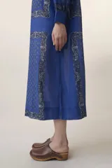 Vestido largo azul con estampado floral, cuello mao y mangas largas.