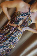 Vestido largo con estampado paisley en tonos tierra y azules, con top halter y cut-outs laterales. La falda es holgada y tiene elástico en la cintura.