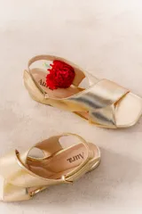Sandalias negras de cuero con tiras cruzadas en el empeine, pulsera al tobillo con hebilla metálica y tacón cuadrado.