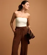 Pantalón pantalona marrón de viscolino, con cintura elástica, bolsillos laterales y lazo ajustable en la cintura.