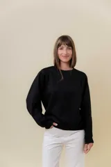 Buzo de manga larga color verde claro, con cuello redondo y calce relajado.