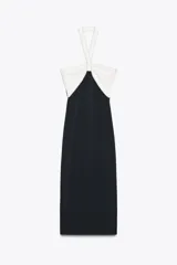 Vestido midi negro de tejido elástico, con escote recto y cuello halter. Presenta un lazo blanco a contraste en el delantero con aplicación de perlas y espalda descubierta.