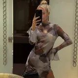 Minivestido de microtul elastizado con estampado abstracto en tonos grises y marrones. Tiene cuello alto, mangas largas acampanadas y abertura lateral en la falda.