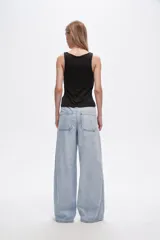 Pantalón de jean celeste de corte ancho con bolsillos y detalle de franja blanca en los laterales.