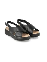 Sandalia negra de cuero con plataforma y tiras cruzadas.