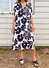 Vestido midi de manga corta con cuello camisero en V y estampado floral grande en azul marino y blanco.