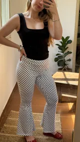 Pantalón de lycra blanco con estampado de lunares negros, corte ajustado y tiro alto.