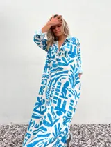 Vestido camisero largo de corte amplio, con estampado abstracto en tonos celeste y crudo.