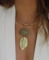 Collar de bronce con diseño artístico que incluye una hoja y elementos geométricos.