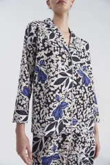 Pijama de camisa y pantalón con estampado floral exclusivo, diseñado por Justa Petra, con mangas largas y detalles en lurex plateado.
