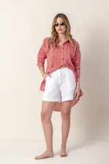 Camisa larga a rayas verticales rojas y blancas, con cuello camisero y cierre frontal con botones.