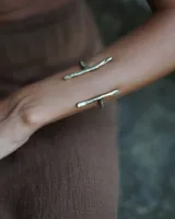 Brazalete abierto de bronce con forma de rama.