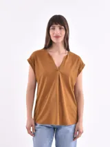 Blusa blanca de corte holgado, con cuello en V y mangas cortas.