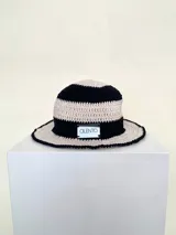 Sombrero tipo bucket tejido a crochet a mano, con hilo 100% algodón y diseño a rayas en tonos rosa y rojo. Presenta una etiqueta con el logo de la marca Cilento en el frente.