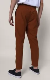 Pantalón de jogging color marrón chocolate, de corte recto y calce regular, con cintura elástica ajustable con cordón, bolsillos laterales y puños con cierre.