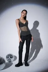 Musculosa sin mangas, ajustada al cuerpo, confeccionada en malla de poliéster con incrustaciones de strass plateados. Presenta escote en V profundo y tirantes anchos.