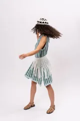 Vestido tejido a rayas verticales en tonos celeste y gris, sin mangas y largo a la rodilla. Incluye cinturón tejido con flecos.