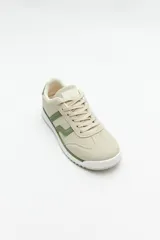 Zapatillas beige con recortes en gamuza de diferentes tonos, cordones y suela irregular blanca con detalle rosa.