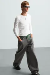 Pantalón de jean gris de corte amplio, estilo balloon fit, con cinco bolsillos, cierre frontal con cremallera y botón, y efecto de color lavado en toda la prenda.