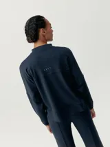 Campera negra de manga murciélago con cierre frontal y bolsillos laterales.