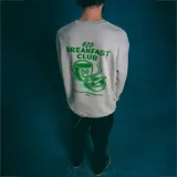 Buzo gris con cuello redondo y puños y cintura acanalados. Estampado pequeño en el pecho con la leyenda "420 Breakfast Club" en color verde.