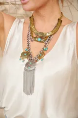 Collar de múltiples capas con cadenas doradas y plateadas, adornos circulares y colgante con flecos.