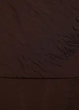 Vestido midi marrón sin mangas, con cuello redondo, corte evasé y bajo abullonado.