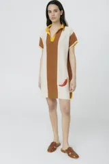 Vestido corto tejido en jersey liviano de algodón y acrílico, con diseño tipo polo y fit holgado. Presenta rayas verticales en color marrón y crudo, bordado XL de un ají y terminaciones en color amarillo.
